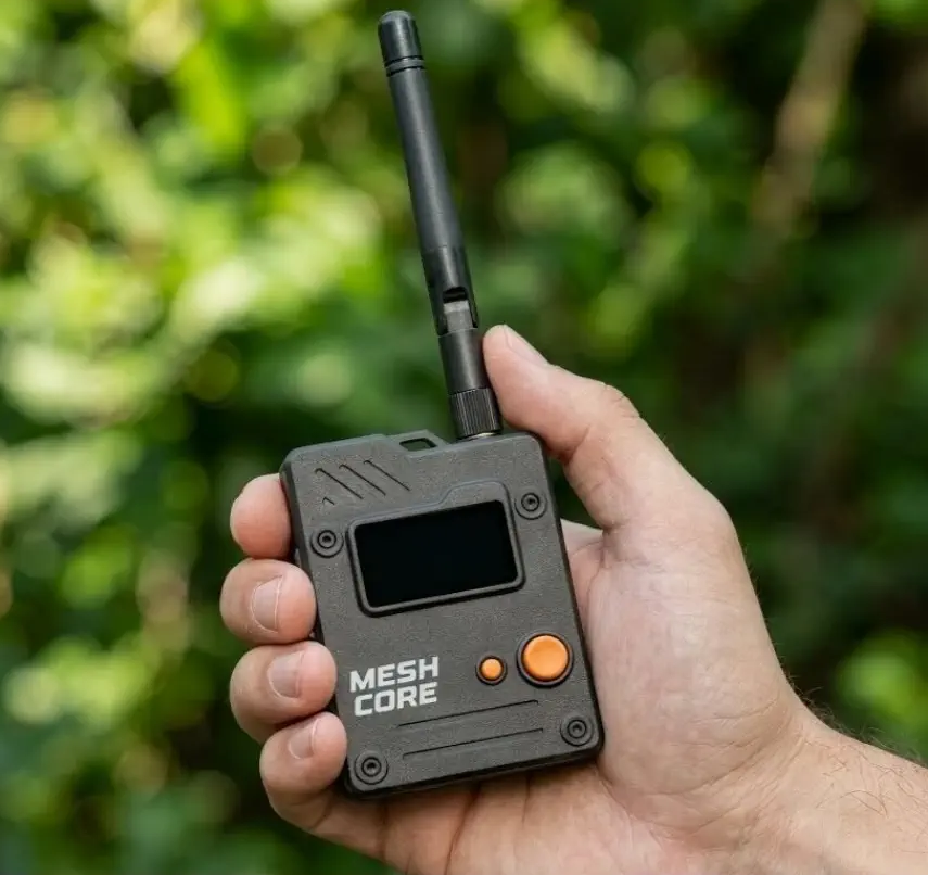 Hand holding a compact MeshCore LoRa radio with an antenna
